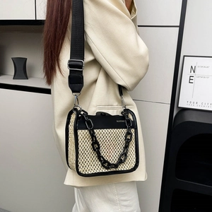Fashionable beige straw crossbody bag with black PU trim and decorative chain strap