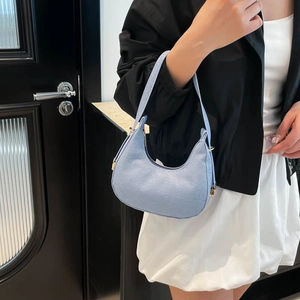 Minimalist light blue hobo shoulder bag with textured surface and stylish crescent design
