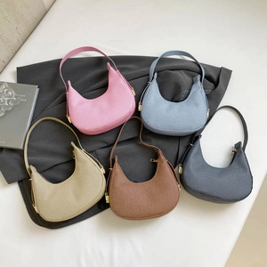 Minimalist half-moon underarm bags in five colors with textured twill and gold hardware