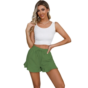Detail of green linen shorts with elastic drawstring waist and feminine ruffle hem