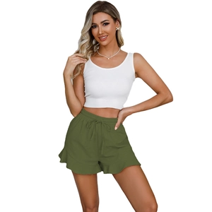 Detail of olive green high-waisted linen shorts with drawstring and ruffled hem