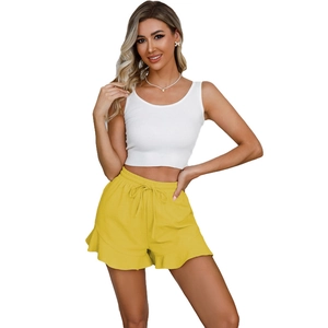 Close-up of bright yellow ruffled hem shorts with elastic drawstring waist detail