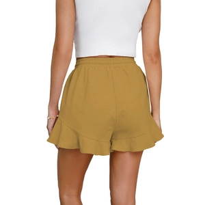 Rear view of mustard yellow high-waisted shorts with ruffled hem and elastic waistband