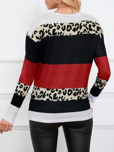 Detail van de ronde hals top met rood-zwart-witte strepen en stijlvolle luipaardprints