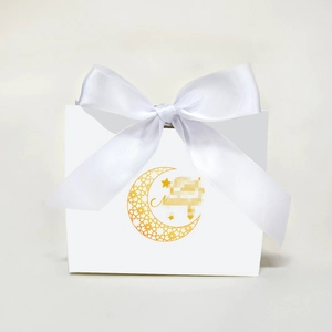 White festive candy box with golden moon and stars patterns and a large satin bow