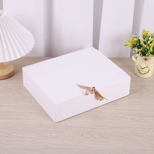 Detailansicht einer weißen matten Klapp-Geschenkbox mit einer zarten hellgoldenen Schleife