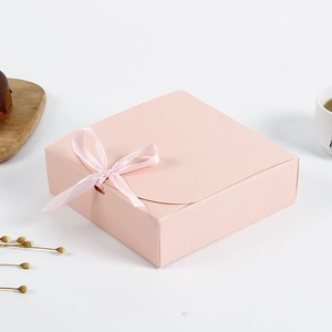Nahaufnahme der rosa quadratischen Geschenkbox mit Schleife und eleganter Mattoptik