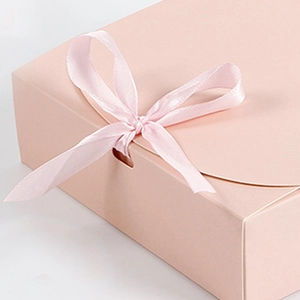 Nahaufnahme einer rosa Geschenkbox mit Satin-Schleife und matter Textur