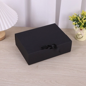Elegante schwarze matte Geschenkschachtel mit Seifenschleife auf einem Holztisch