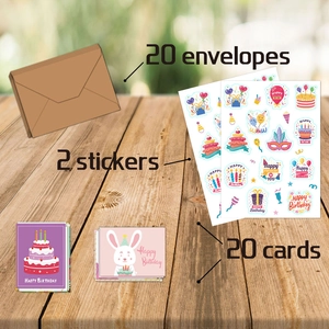 Detail view of 20 cartoon birthday cards with envelopes and stickers on a wooden desk
