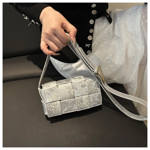 Detailsicht der geflochtenen quadratischen Tasche mit Schlangenmuster und Metallschnalle