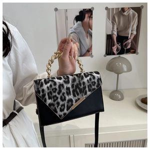 Dettaglio della borsa leopardata con manico in metallo dorato intrecciato e patta