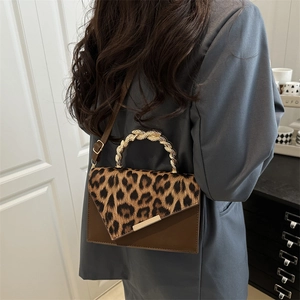 Borsa a tracolla leopardata con manico a spirale dorato e design con patta a V