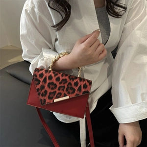 Borsa chic in pelle rossa con patta leopardata ed elegante manico in corda dorata