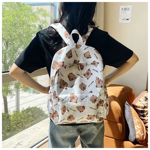 Detail view of large capacity white backpack with brown capybara print and side pocket