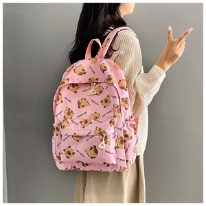 Side view of pink casual backpack with cute capybara patterns worn by model in light gray setting