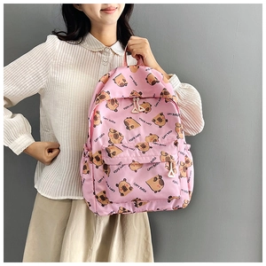 Pink backpack with cartoon capybara print featuring front pocket and side pockets