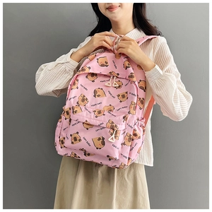 Detailed view of pink backpack with cartoon capybara print and front zipper pocket