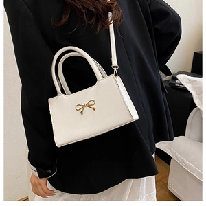 Détail d'un sac à main blanc chic avec boucle en métal doré et texture en similicuir