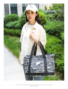 Outdoor model shot of zebra print travel bag with large capacity and sturdy black handles