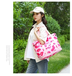 Detailed view of pink patterned yoga travel bag carried by a model in outdoor setting