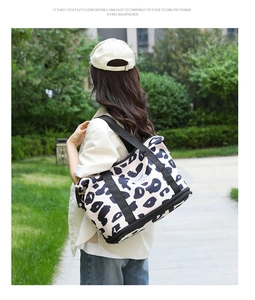 Detail of leopard print travel tote showing the bottom zipper compartment for shoes