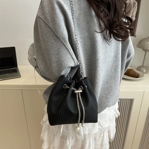 Modische schwarze Beuteltasche mit vertikalem Streifenmuster, Silberkette und Perlendetails