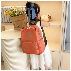 Dettaglio mini zaino in nylon corallo con orecchie da animale e patch a forma di stella