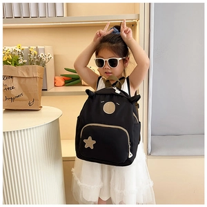 Dettaglio zaino nero per bambini con orecchie a cartone e toppa a forma di stella