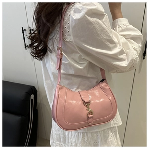 Mannequin portant un sac demi-lune en cuir verni rose avec une boucle dorée chic
