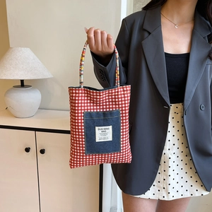 Reversible checkered denim tote bag featuring red lattice pattern and blue denim pocket
