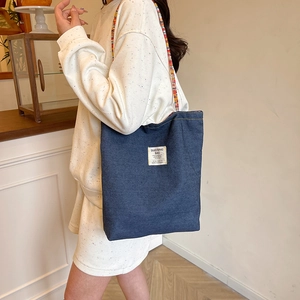 Borsa tote in denim retrò con tracolla intrecciata colorata ed etichetta cucita
