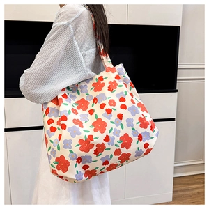 Détail du sac cabas en toile fleurie montrant un motif de fleurs rouges et violettes