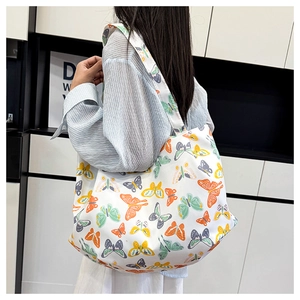 Détail d'un grand sac cabas en toile blanche avec motifs papillons colorés pour femme