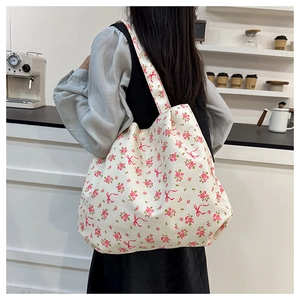 Detail of canvas tote bag with pink floral print and bow design for summer