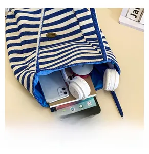 Macro shot of striped canvas tote showing high capacity for laptop and gadgets