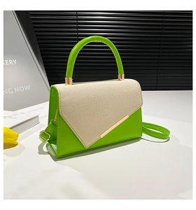 Detail of green and beige square handbag with canvas texture and gold metal accent
