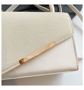 Detail of cream woven texture and smooth leather finish on small crossbody bag