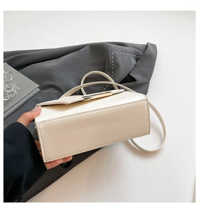 Detail shot of the cream rectangular shoulder bag showing tidy stitching and bottom construction