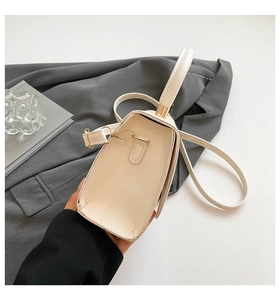 Detail of cream white leather mini square bag with gold hardware and trapezoid structure