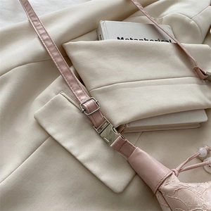 Detailed view of pink floral lace fabric on a crossbody bag with drawstring bead closure