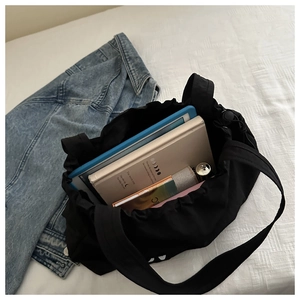 Spacious black canvas tote bag with drawstring closure showing internal storage capacity