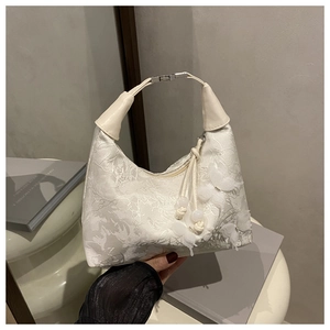 Detail of cream jacquard handbag with delicate mesh 3D butterflies and silver clasp