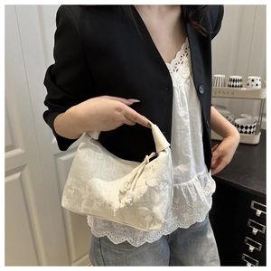 Close-up of white lace jacquard handbag featuring elegant 3D butterfly embroidery detail