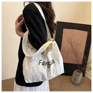 Detail view of large white canvas tote bag with Fangssa text and drawstring closure