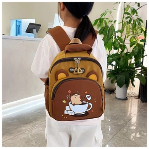 Detalle de mochila infantil con diseño de carpincho, orejas 3D y colores en contraste