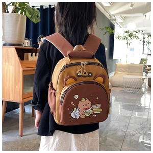 Niño pequeño con mochila bicolor amarillo y marrón con un lindo estampado de carpincho