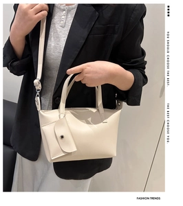 Detail of cream leather bucket bag with matching mini coin purse and adjustable shoulder strap