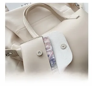 Detail of off-white leather bucket bag with a matching small charm pouch and silver buckle