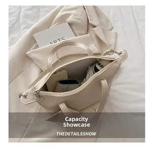 Internal capacity display of a cream faux leather tote bag with daily essentials inside